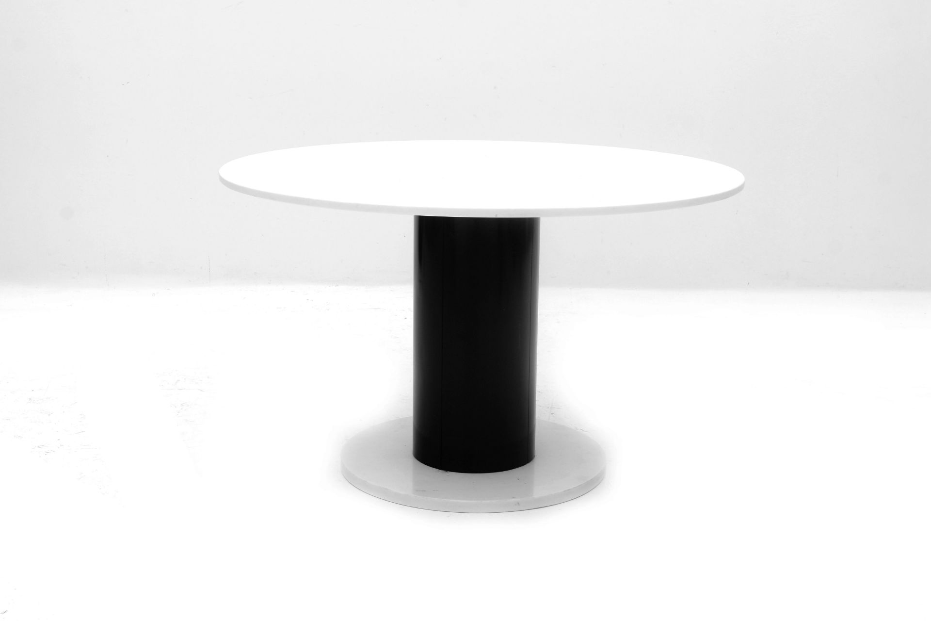 Eighties A circular dining table, white Carrara marble top on cylindrical black lacquered metal on