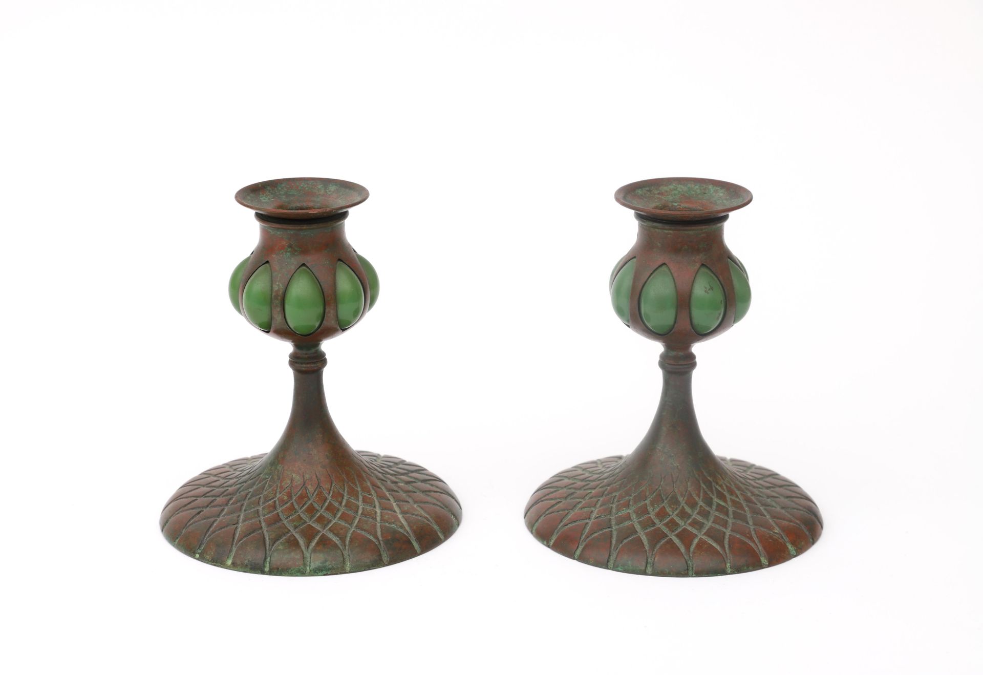 Tiffany Studios, New York A pair of patinated bronze candlesticks with green glass blown tops,