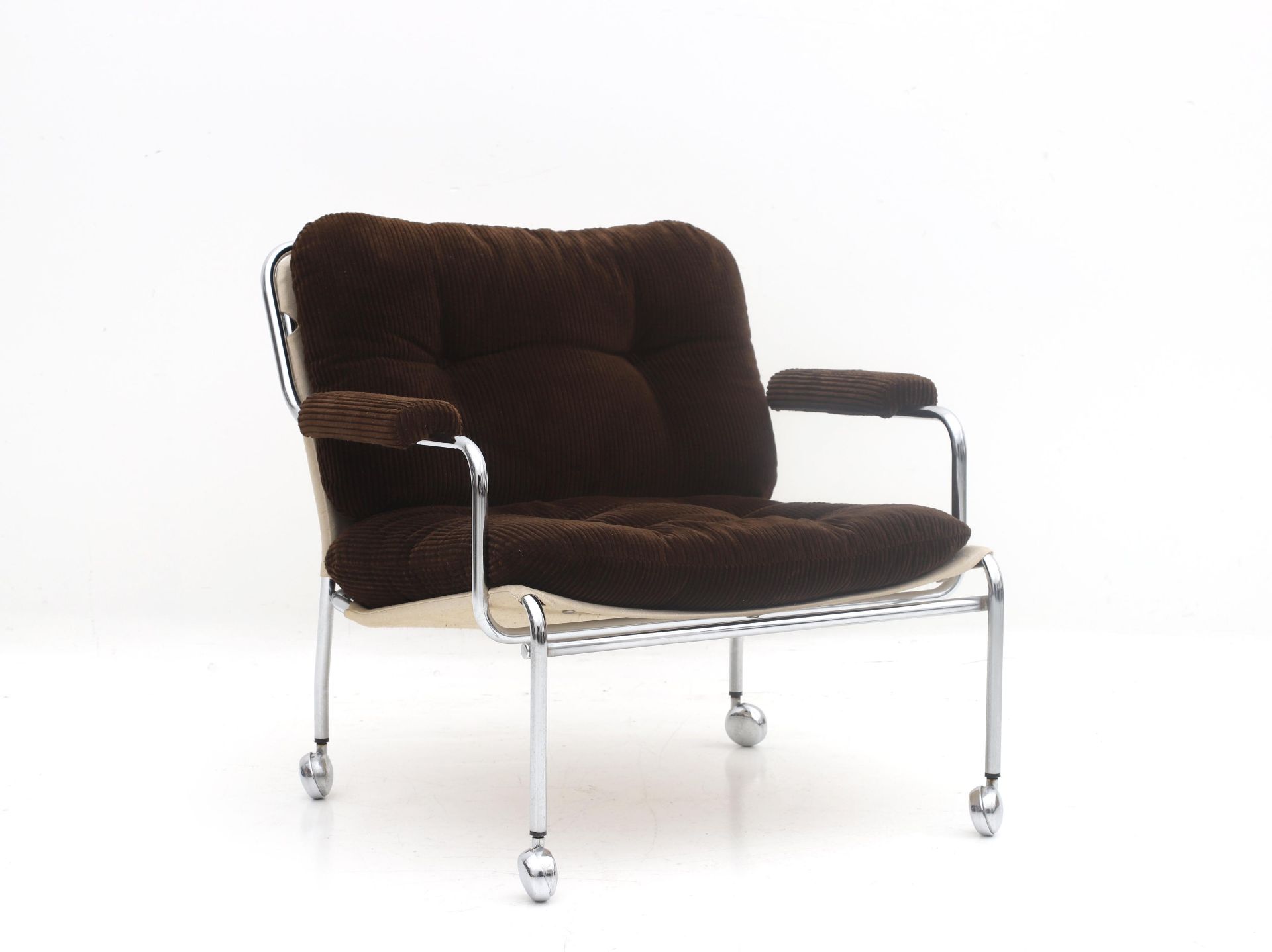 Seventies A chromium plated tubuar steel easy chair on casters, with canvas seat, brown ribbed