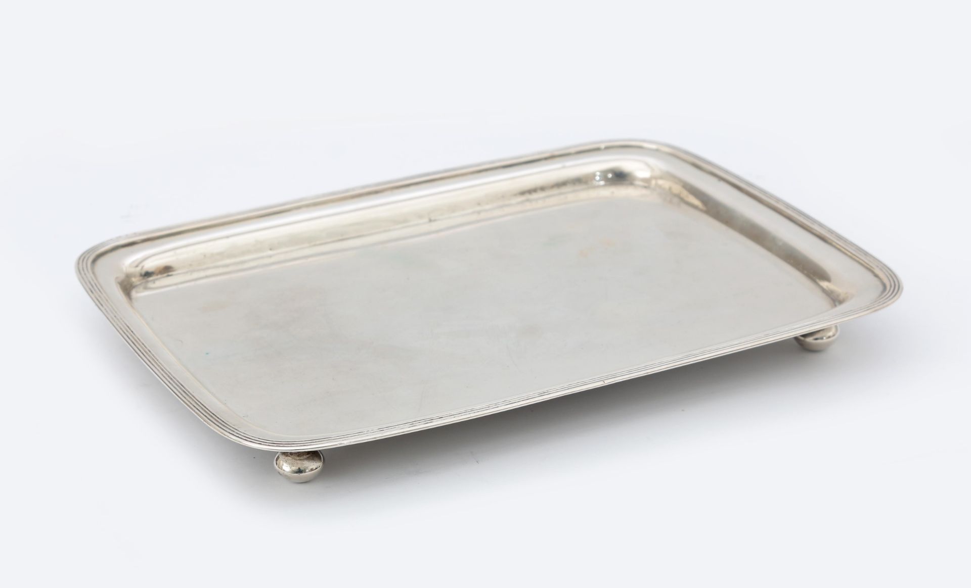 A rectangular 835 silver tray with reeded border on four ball supports, maker's mark: Pieter