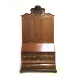 An oakwood Louis XV-style top desk cabinet. Dutch, 19th century. The top section with carved crest,