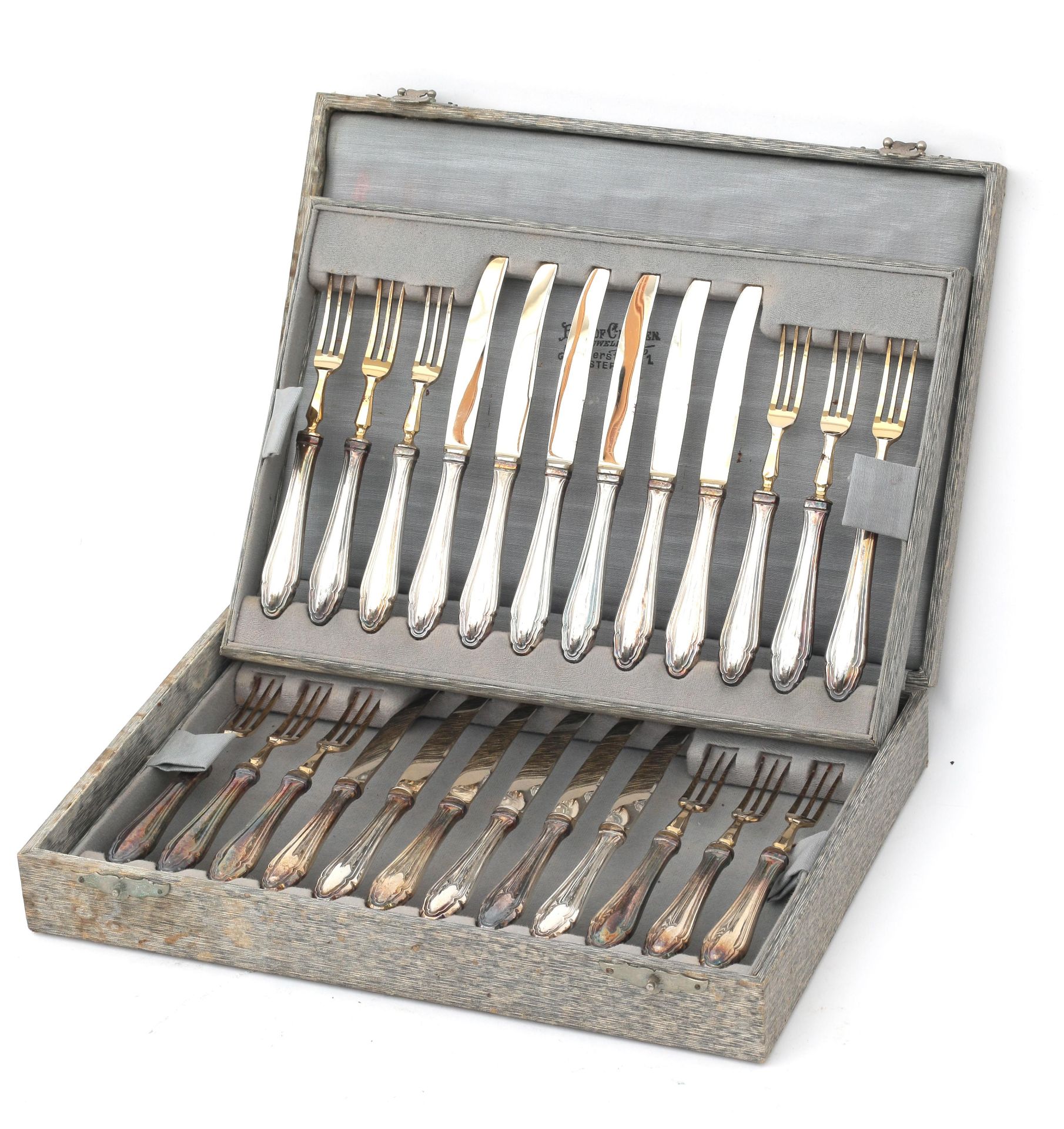 Twelve partially gilded fruit forks and fruit knives with 835 silver handles in case, adress: Roelof
