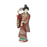 A Satsuma figure of a woman holding a fan and a lantern, first quarter 20th century. H. 29 cm.
