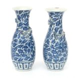 A pair of Chinese blue-and-white porcelain vases decorated with stylized flower and leaf motifs.