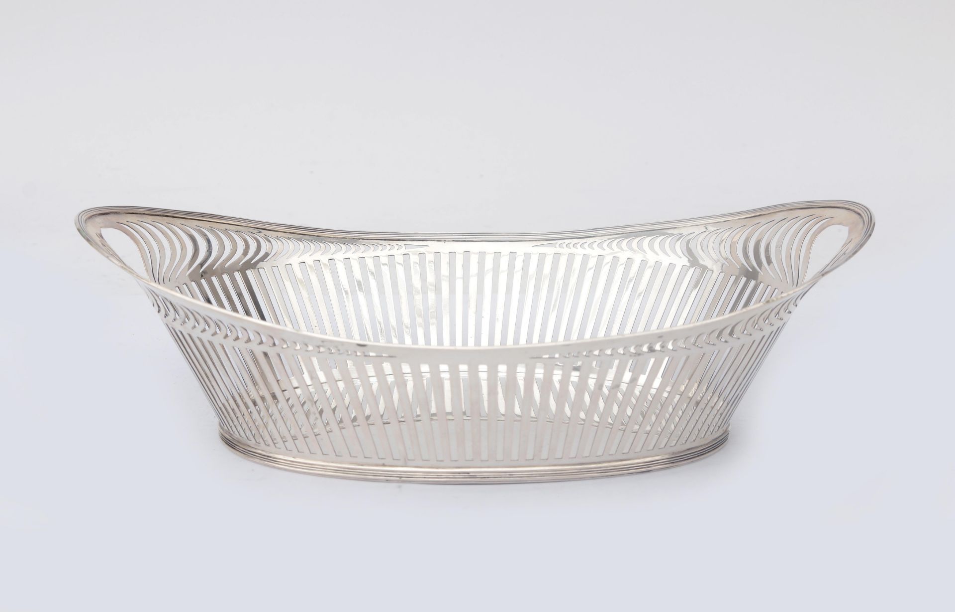A Dutch ajour sawn 2nd grade silver art deco bread basket, with fillet edge resting on a base ring