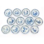 Twelve Chinese porcelain dishes, decorated with a playing child and a woman in a garden in Kangxi-