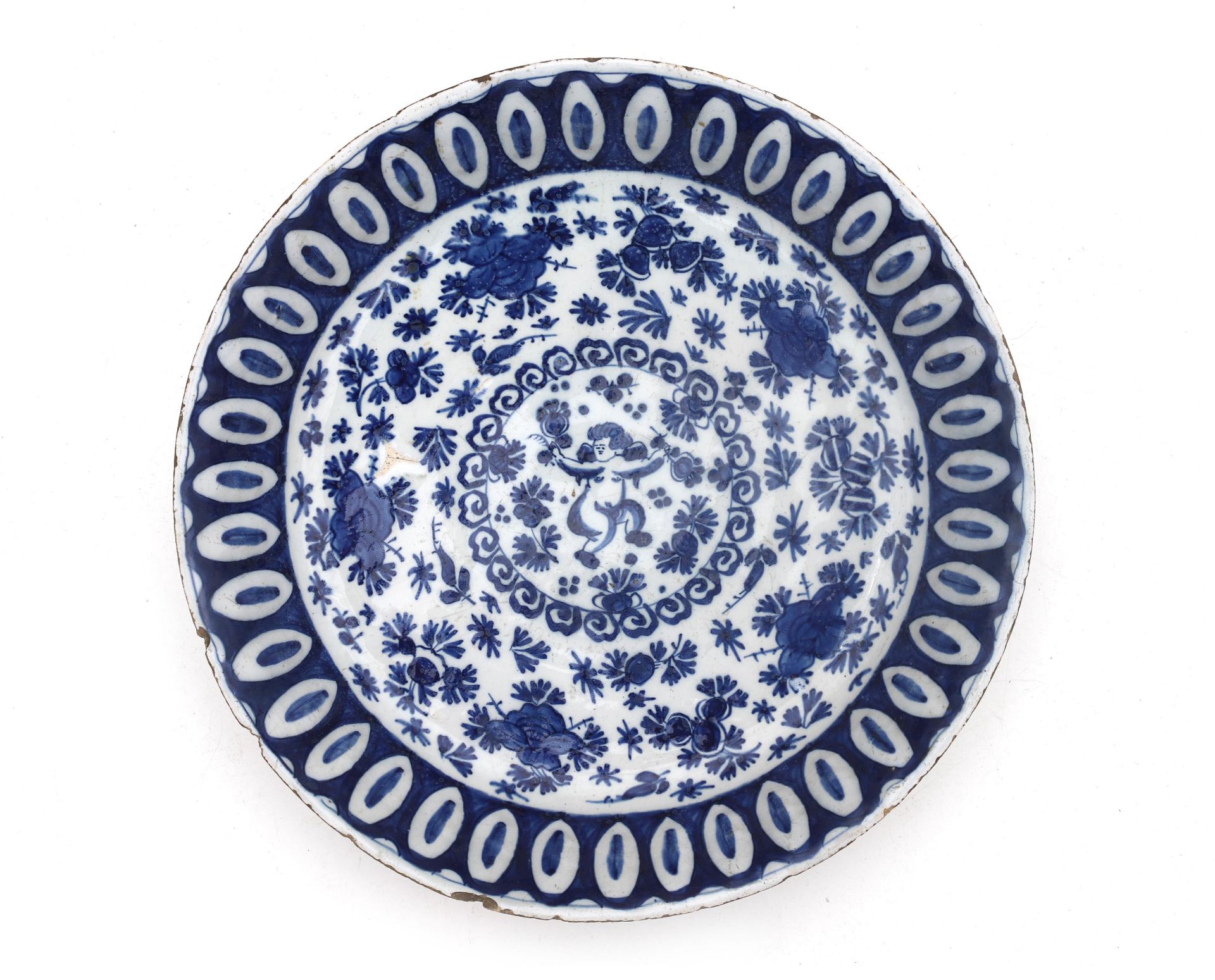 A Delft charger with blue-and-white motif, in the middle a putto, Dutch, 18th century. Diam. 30 cm.
