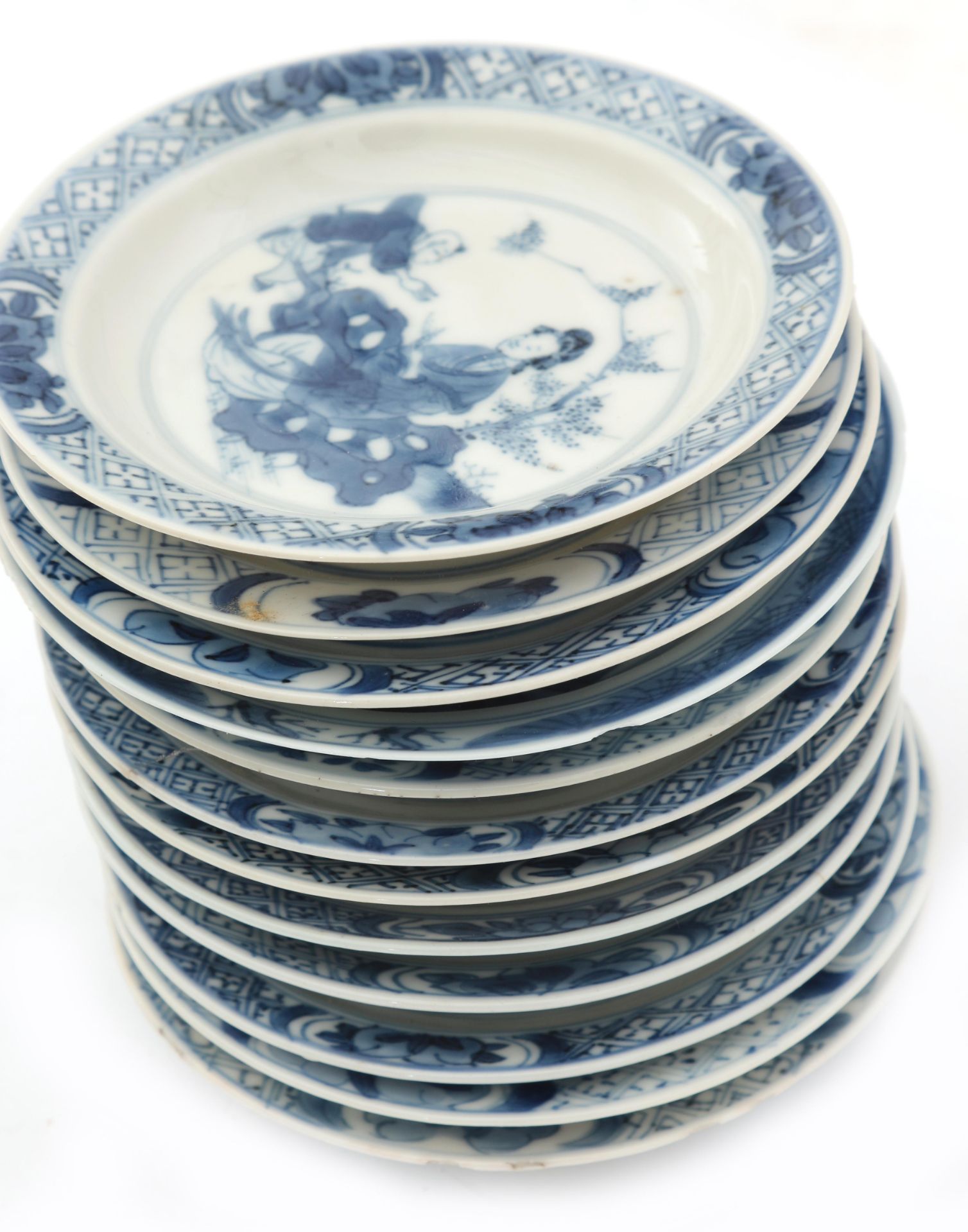 Twelve Chinese porcelain dishes, decorated with a playing child and a woman in a garden in Kangxi- - Image 4 of 4