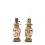 A pair of Japanese Satsuma and bronze mounted oil lamps, decorated with a family in a garden, circa