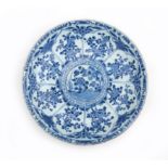 A Chinese porcelain Kangxi dish decorated with blosoms and flowers in panels, marked with the