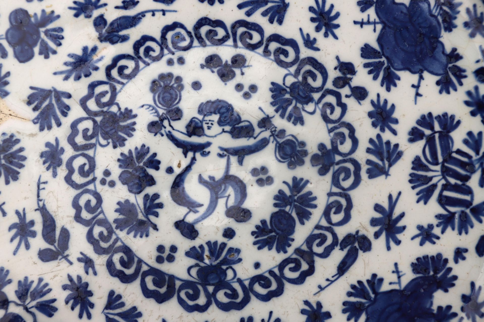 A Delft charger with blue-and-white motif, in the middle a putto, Dutch, 18th century. Diam. 30 cm. - Bild 4 aus 4