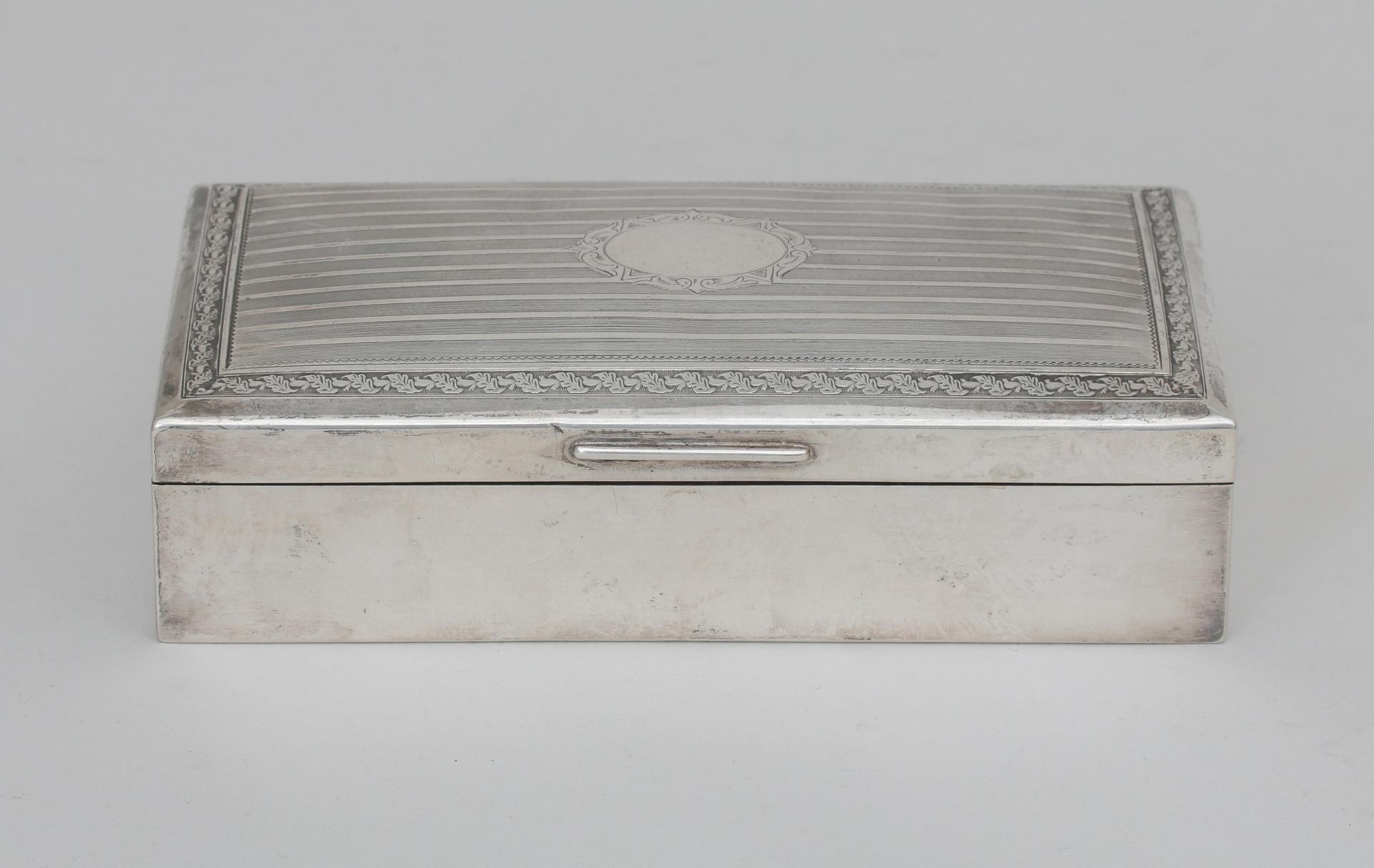 A German 835 silver cigarette case with oak leaf border and line decoration, maker's mark: Wilhem