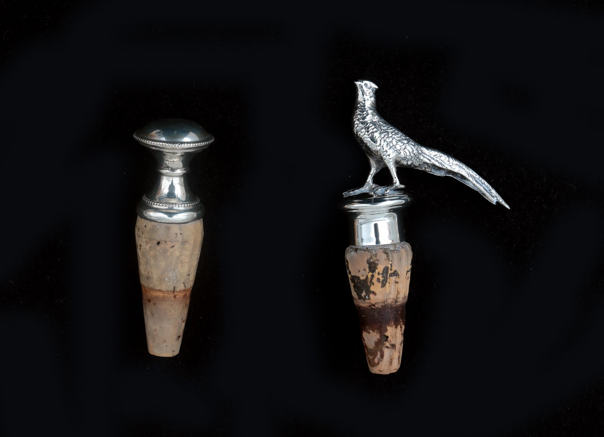A pair of silver decorative corks, one with a miniature silver pheasant, this one sterling silver,