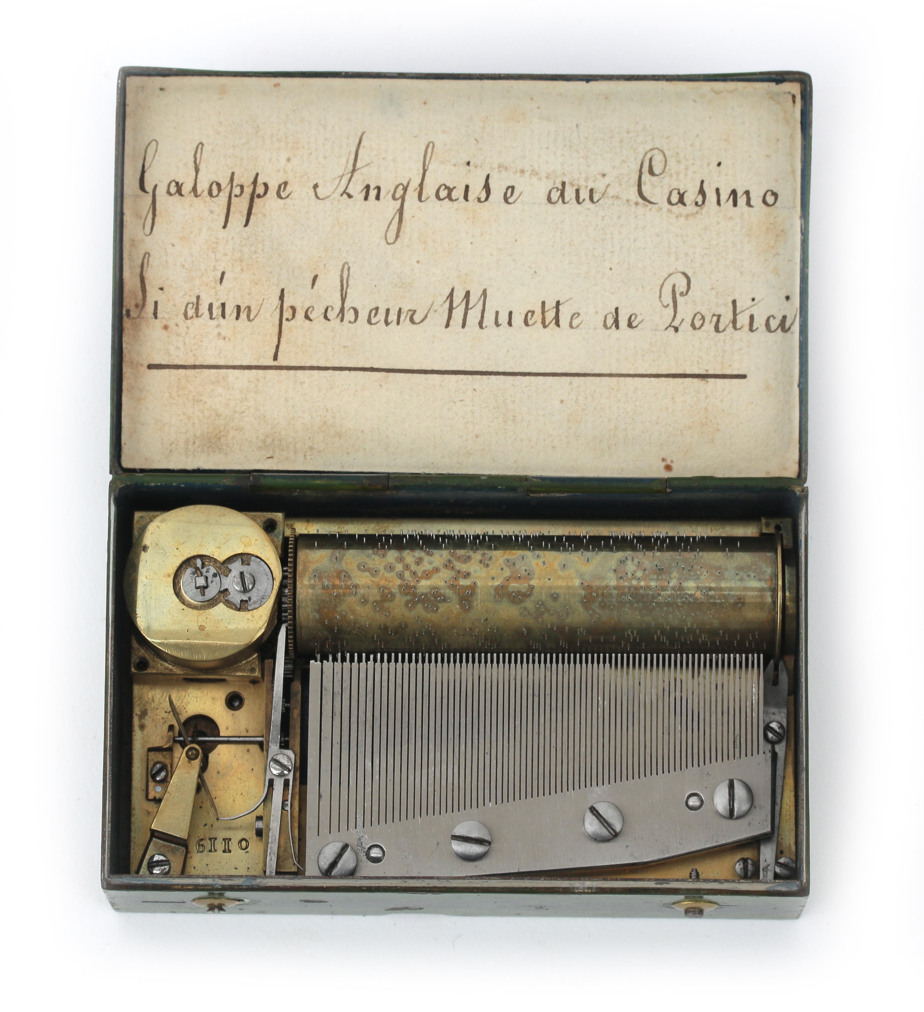 A Swiss souvenir cylinder music box in green tin case decorated with a landscape with the text: - Image 2 of 4