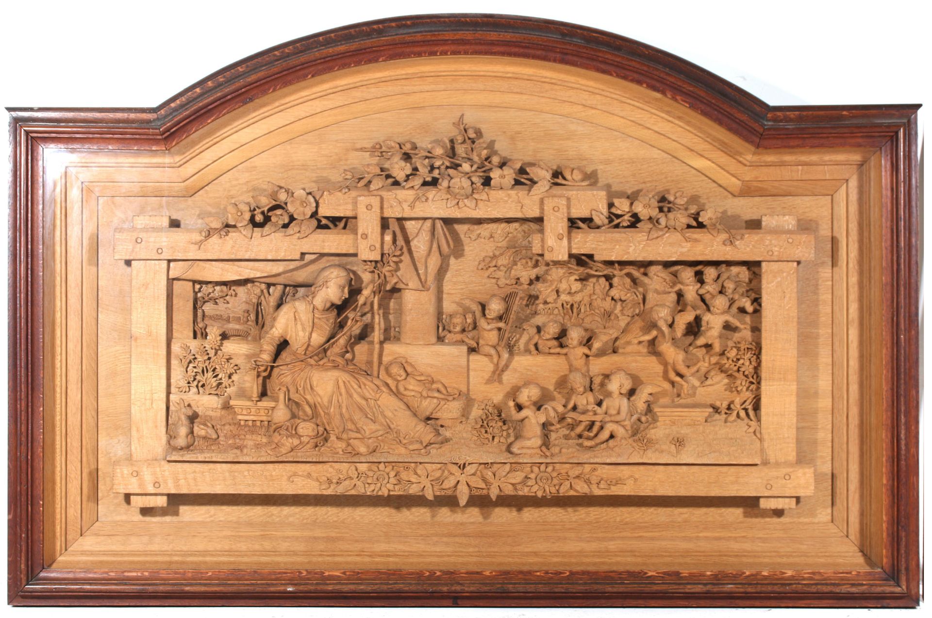 A carved wooden relief with scene of a spinster with children and putti, Germany, late 19th
