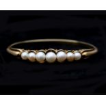 A 14 karat gold bangle with Akoya pearls