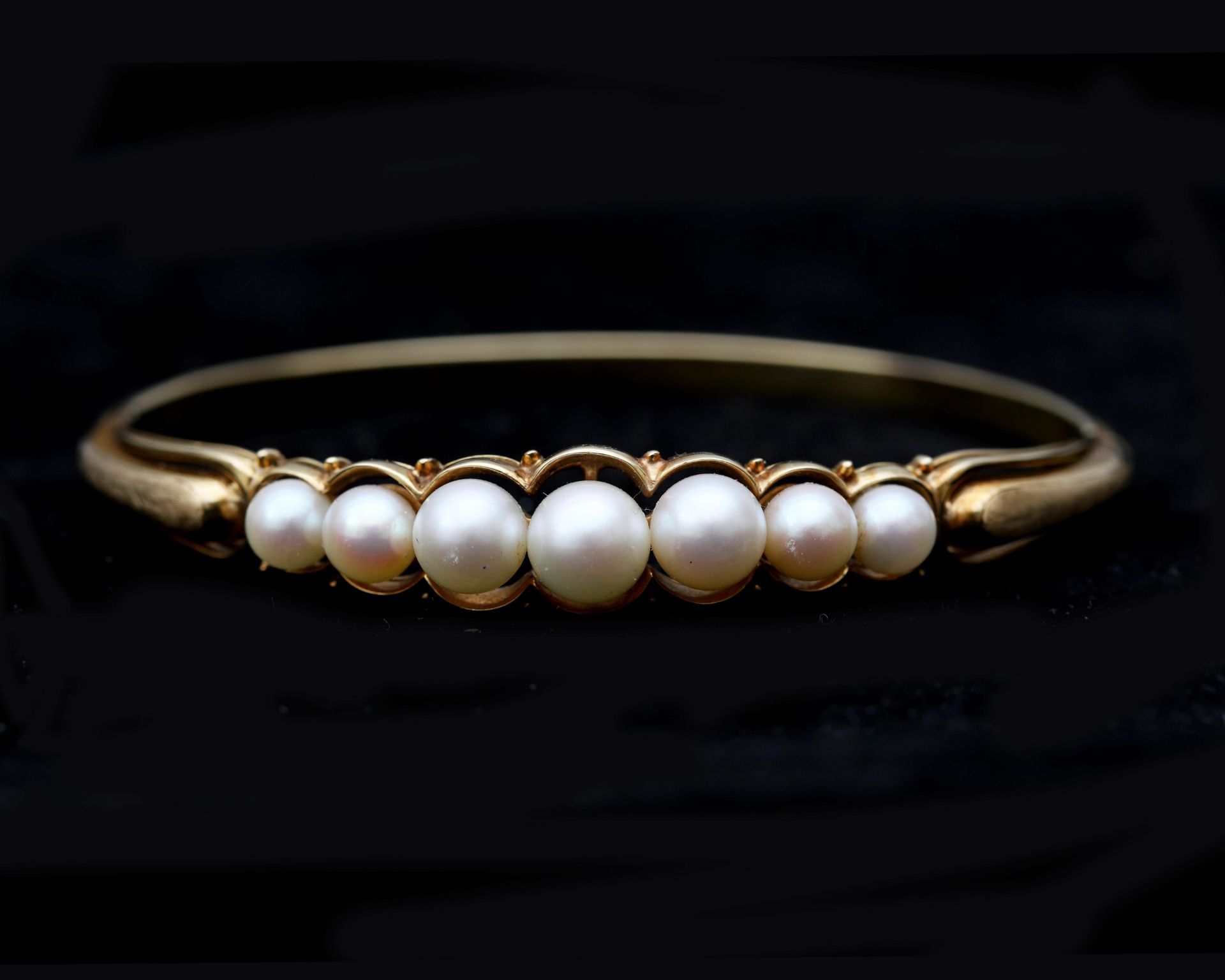 A 14 karat gold bangle with Akoya pearls 