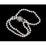 A pearl bracelet with a 14 karat white gold decorative clasp set with diamonds