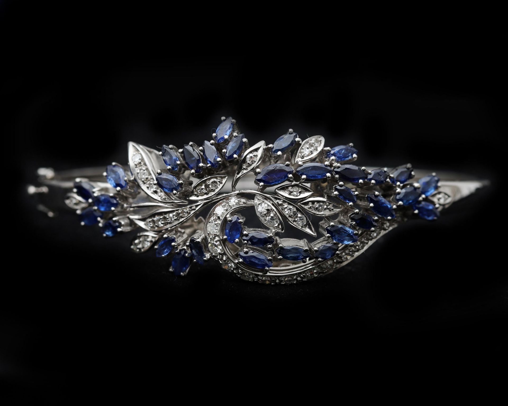 An 18 karat white gold bangel bracelet, with diamonds and sapphire