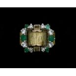 An 18 karat gold ring with diamonds and emeralds