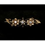 A 14 karat gold floral decorated brooch set with three cubic zirconias
