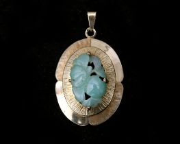 A 14 karat vintage oval pendant set with an oval jade 