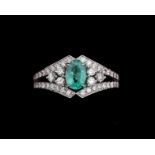 An 18 karat white gold ring centrally set with emerald and diamonds