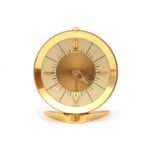 Jaeger A gilt brass travel alarm clock in red box, midcentury, marked to the dial. 5 cm. h.