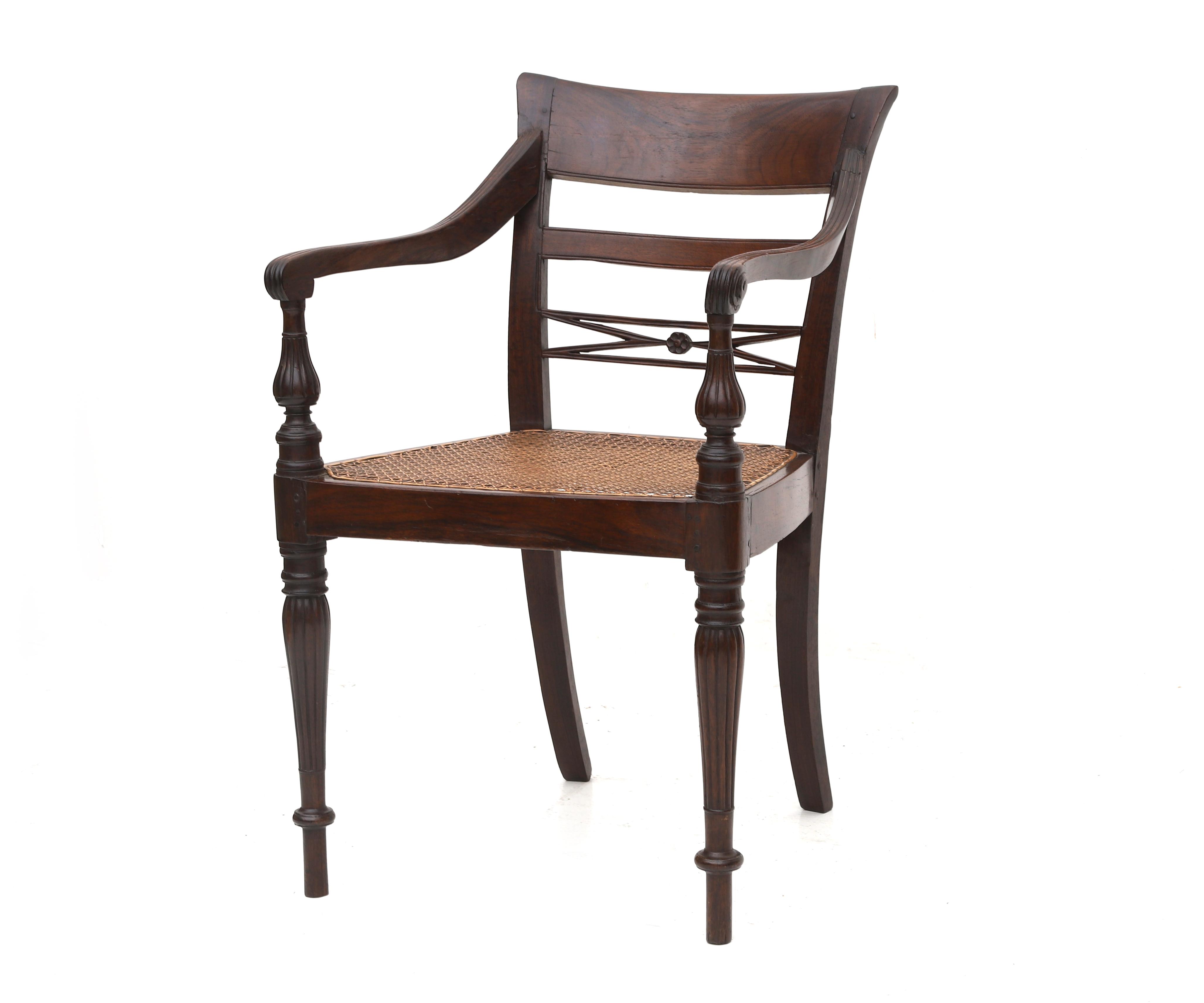 The open back with carved ornaments, webbing seat, armrests with carved details, four tapering