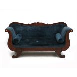 The back with carved scroll in the centre, the armrests double curved, gilt rosettes at the end,