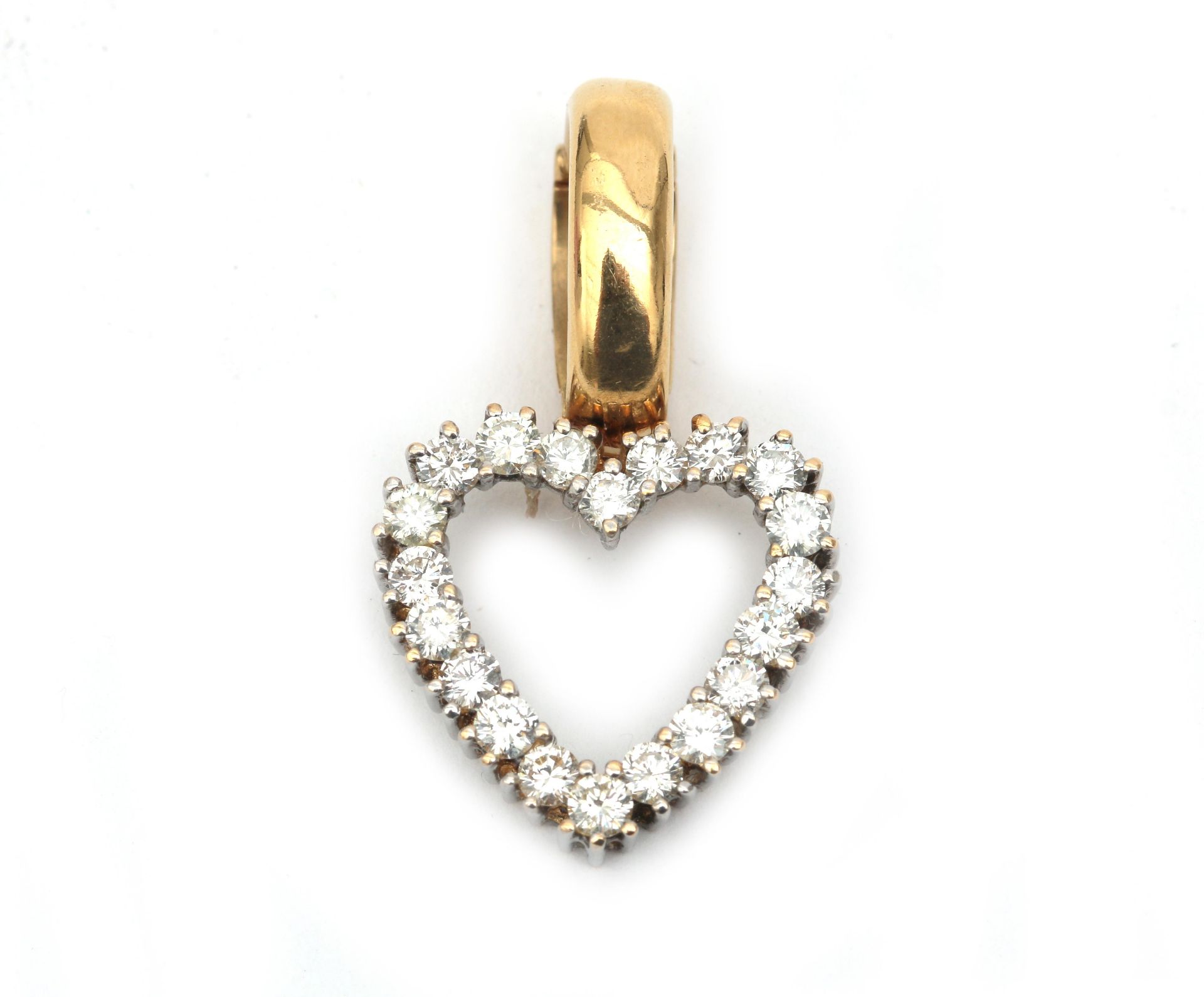 A 14 karat gold diamond set heart shaped pendant. Featuring twenty brilliant cut diamonds, ca. 1.