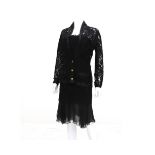 A Chanel Boutique ensemble of a lace black dress, blazer and slip. The blazer has gold-colored