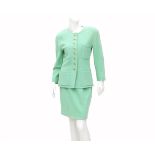 A Chanel Boutique ensemble of a pastel green blazer and skirt. The blazer has four external