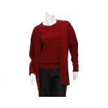 A burgundy red Chanel twin set of a sweater and a cardigan. The cardigan has mother-of-pearl buttens