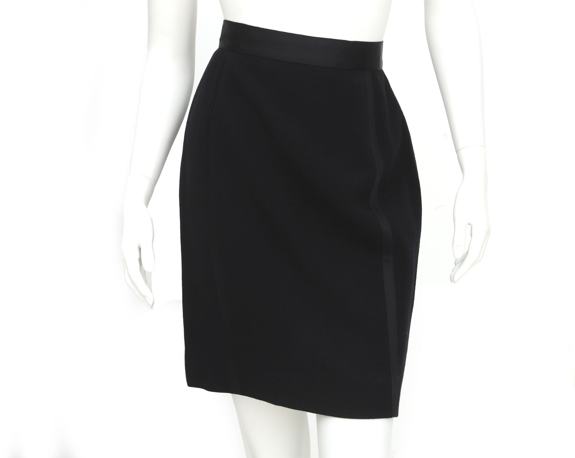 A black Chanel pencil skirt with stripe details down the length of the skirt. With two golden waffle