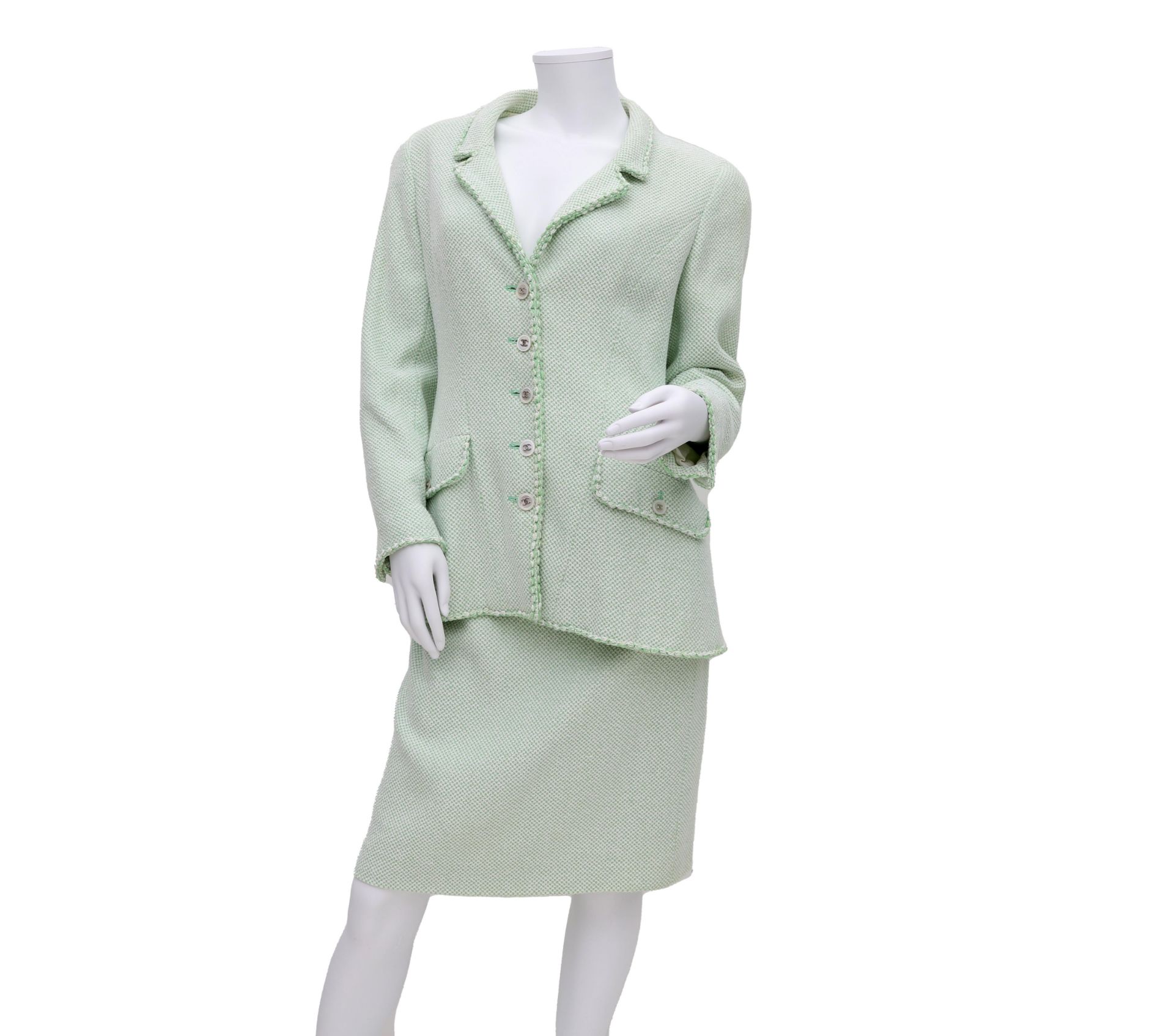 A Chanel Boutique ensamble a green and white mixed blazer and a skirt. The blazer has a reverse
