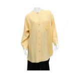 A Chanel Boutique yellow blouse, the blouse has an external pocket with the CC logo embroidered