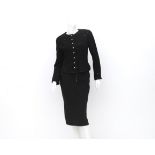 A Chanel Boutique ensemble of a black blazer and a skirt. The blazer has a classic high neckline and