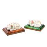 A pair of reclining catsJapanese porcelain Polychrome decoration With a pair of carved and