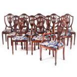 A set of twelve chairsTwo armchairs Mahogany and other timbers Shield shaped back of urn