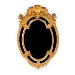 A wall mirrorCarved and gilt wood and gesso Sectioned wood of central oval bevelled glass Floral