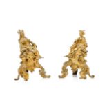 A pair of Louis XV style firedogsGilt bronze Surmounted by figures and with shells and foliage
