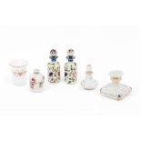 Five different perfume bottles and a drinking glass