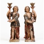 A pair of large candle holding figures