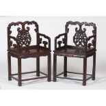 A pair of carved hardwood armchairs