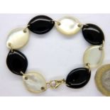Contemporary bracelet formed with alternating panels of onyx and mother of pearl, with 9ct gold