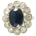 French platinum cocktail ring comprising a large faceted sapphire surrounded by twelve old cut