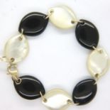 Contemporary bracelet formed with alternating panels of onyx and mother of pearl, with 9ct gold