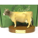 Boxed Beswick matt Jersey cow on wooden plinth, L: 16 cm. P&P Group 2 (£18+VAT for the first lot and