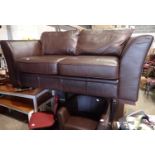 Brown leather two seater sofa and a brown leather tub chair with pouffe. Not available for in-